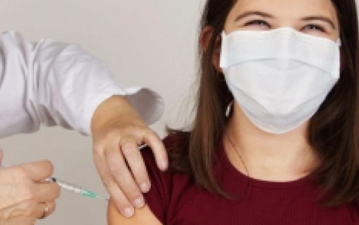 La foto mostra un'operatrice sanitaria mentre effettua la vaccinazione ad una paziente